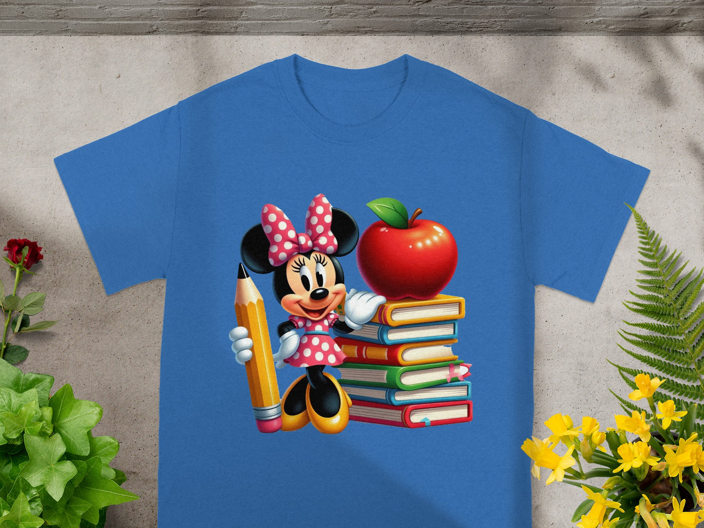 Minnie Mouse in polka dots holds a pencil next to a stack of books and an apple.