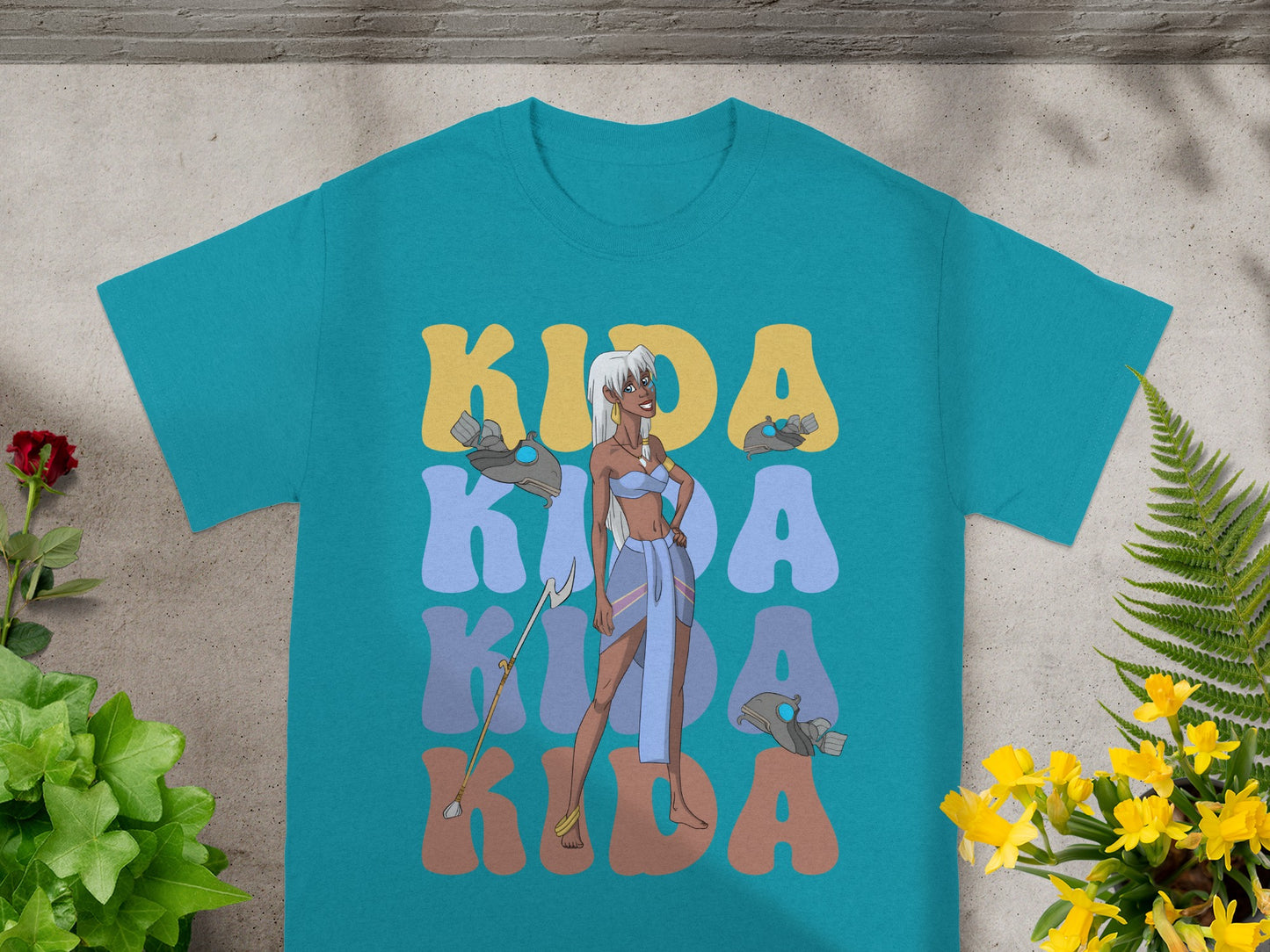Kida standing in front of "KIDA" text on a teal t-shirt.