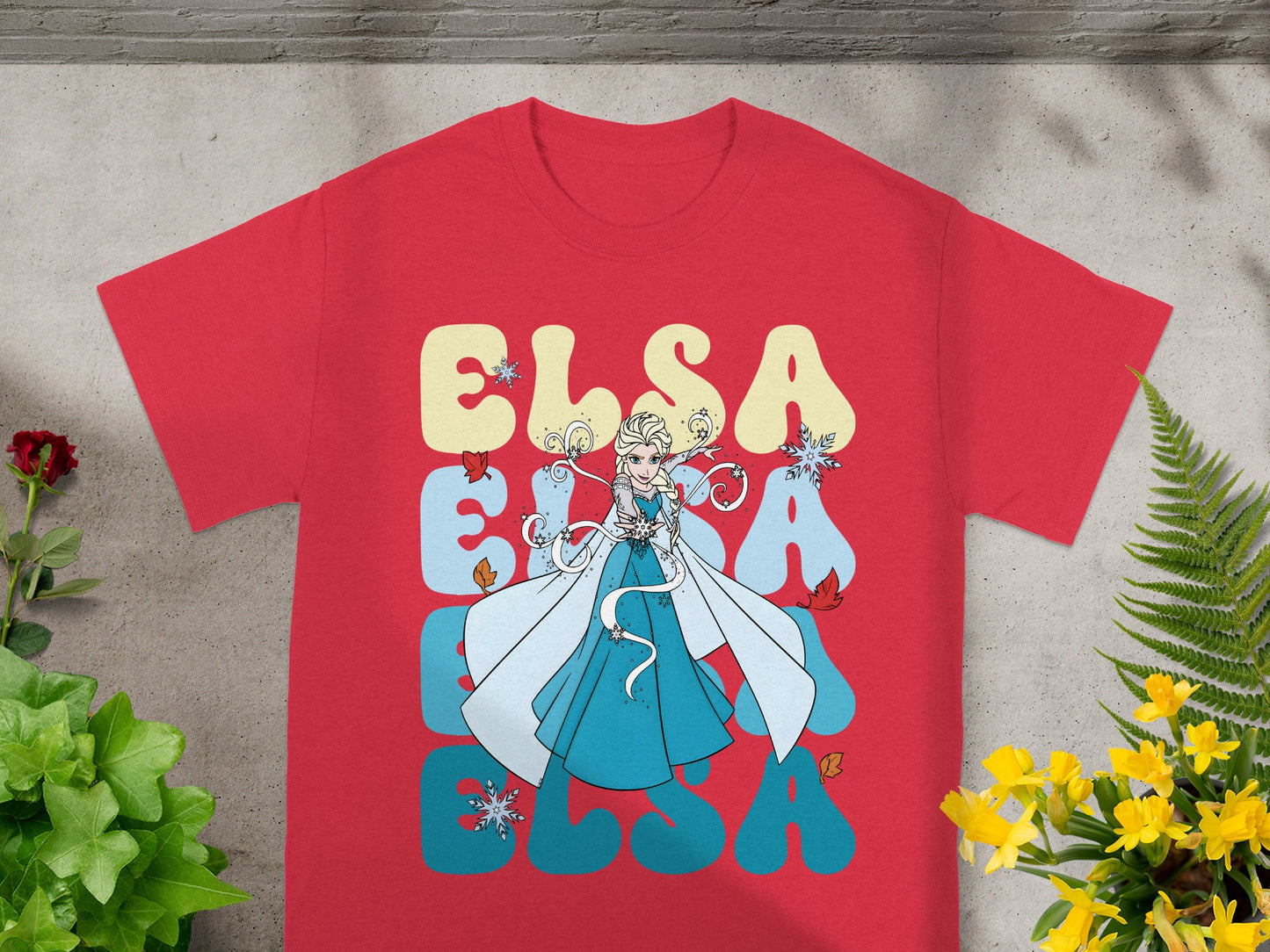 Red t-shirt with Elsa from Frozen graphic and text.
