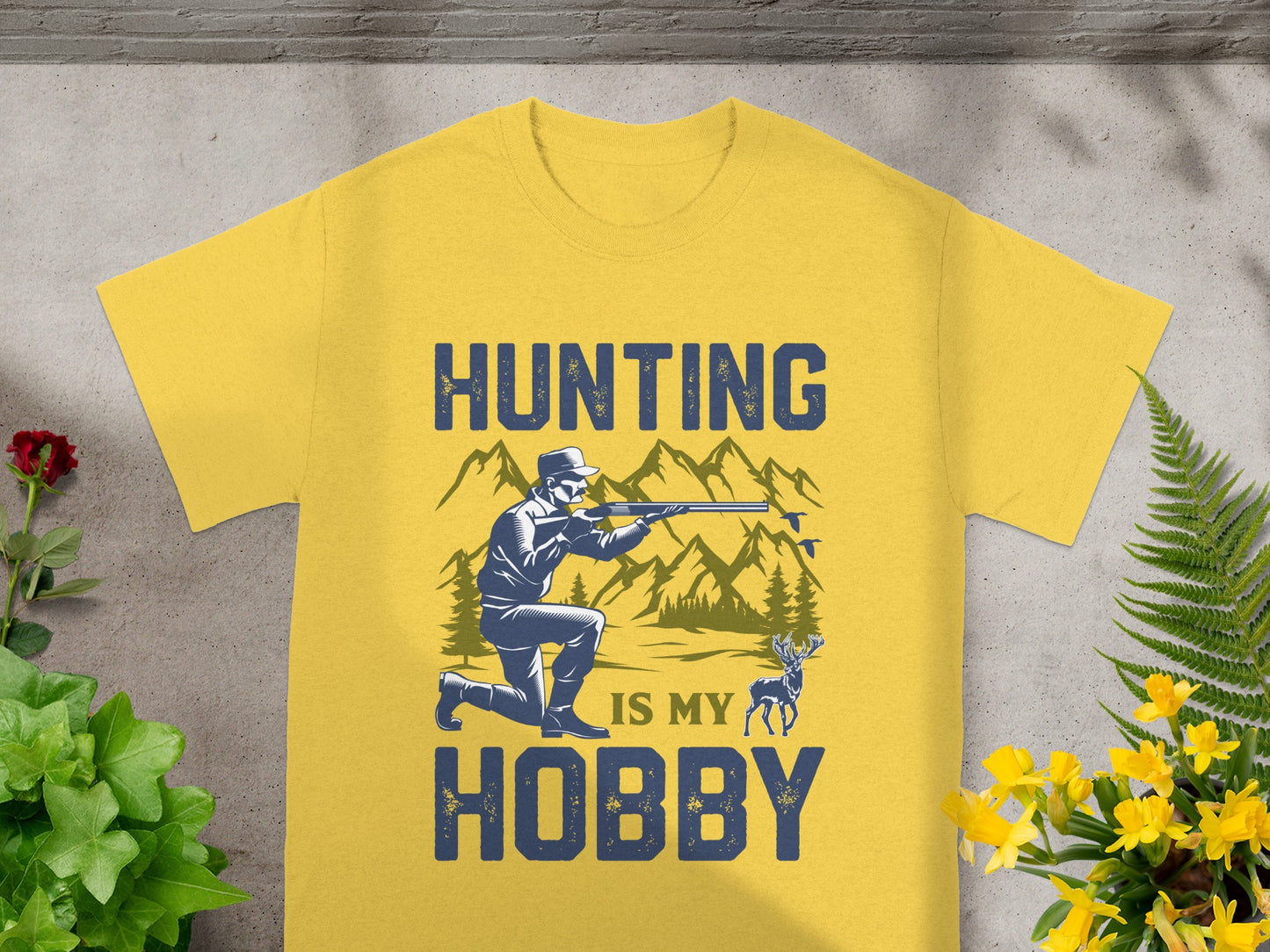 Yellow t-shirt with "Hunting Is My Hobby" text, hunter, deer, and mountains.
