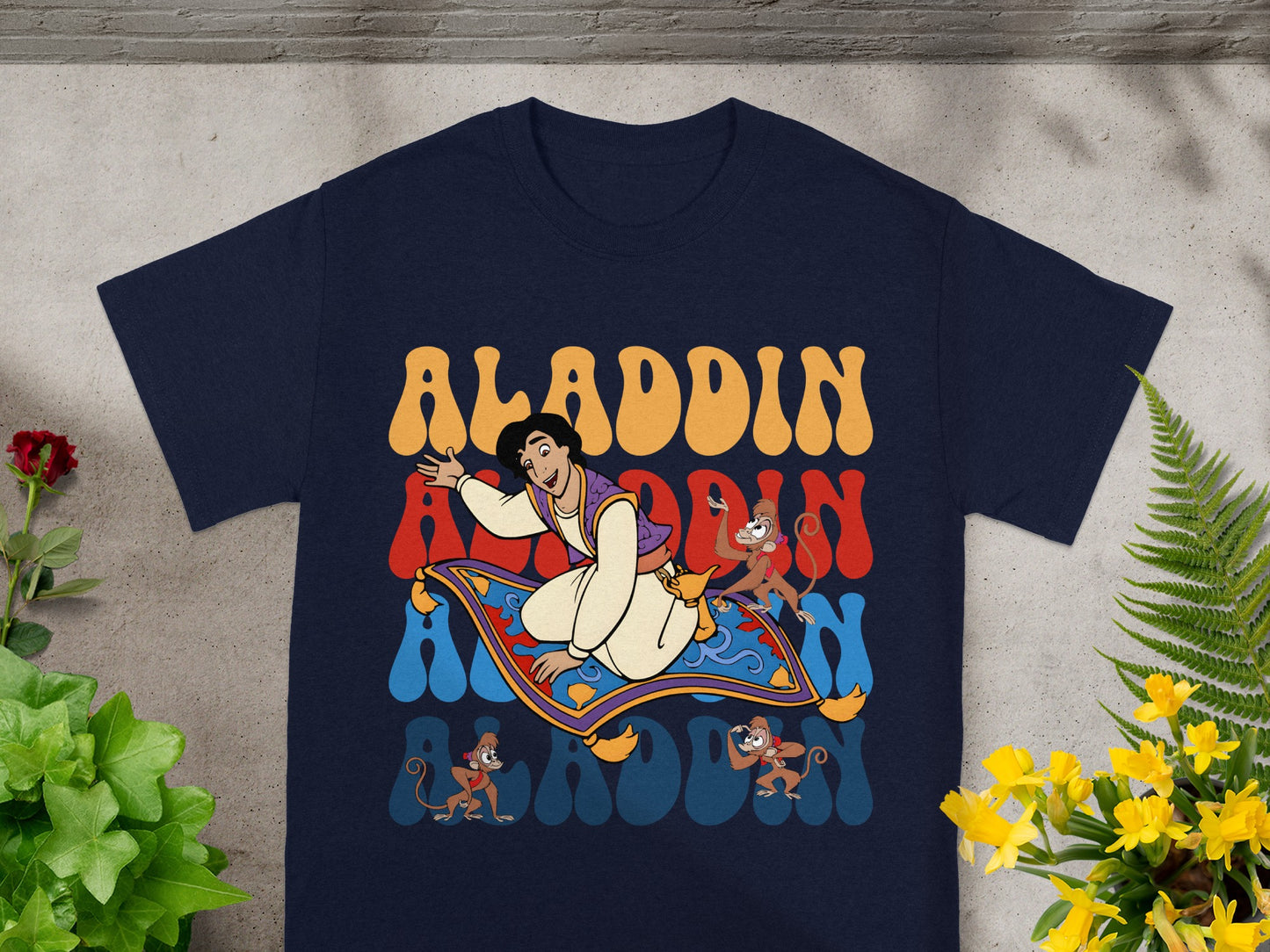 Aladdin and monkeys on magic carpet with "Aladdin" text.