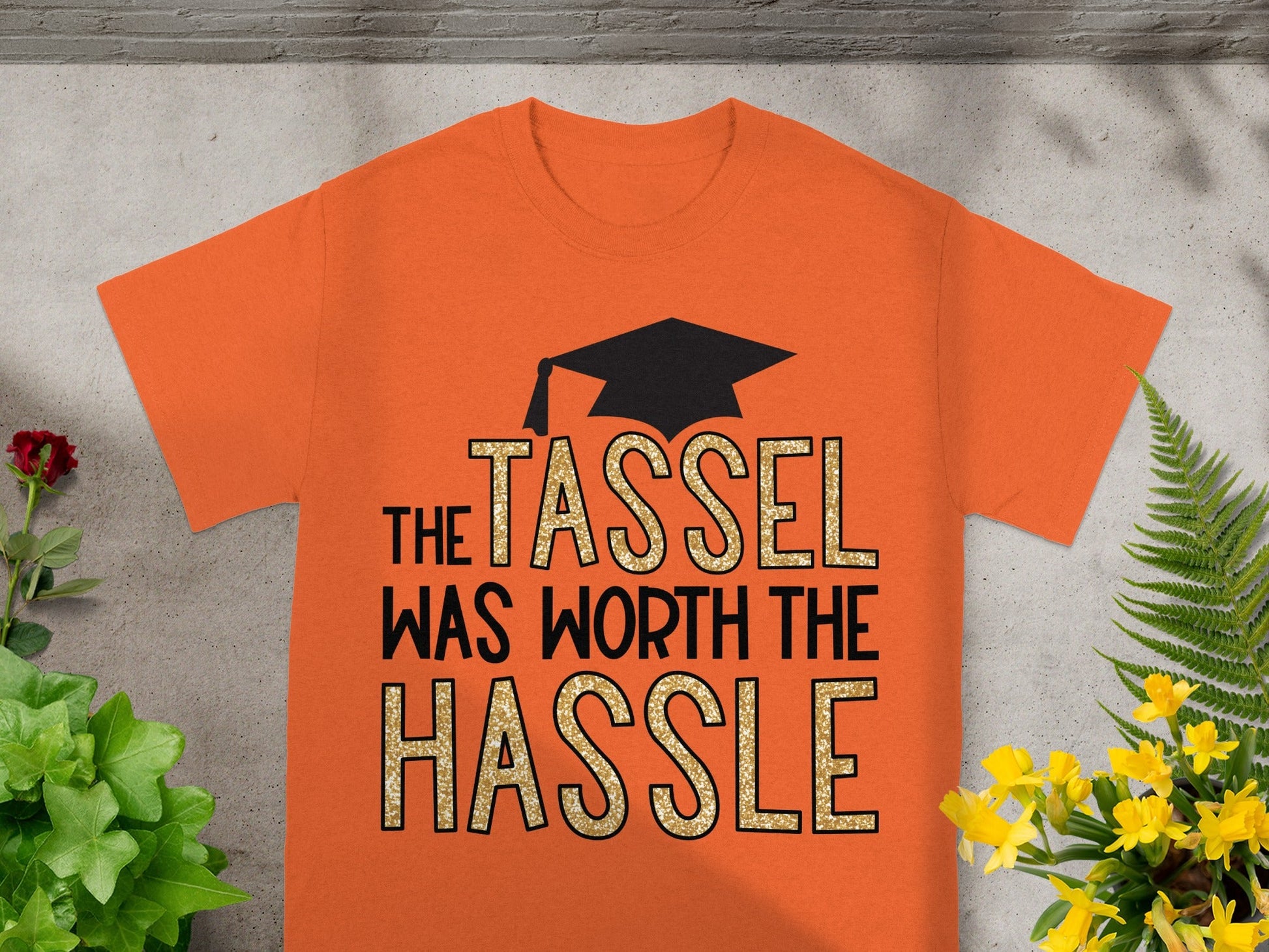 Orange t-shirt with graduation cap and "The tassel was worth the hassle" text.
