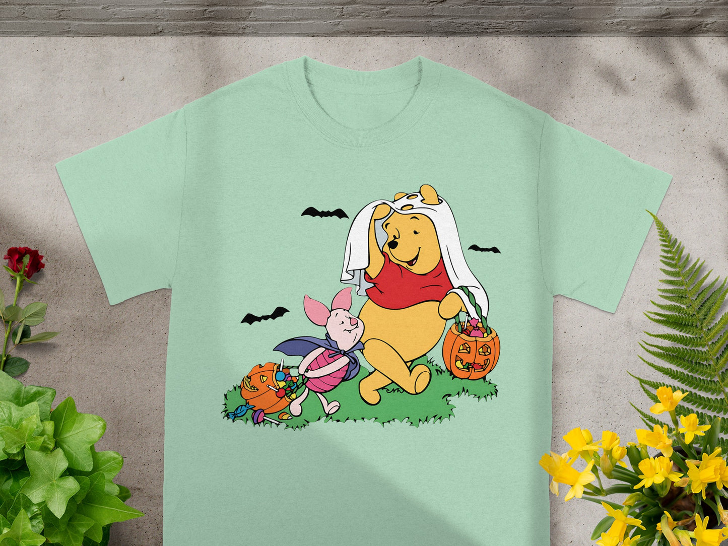 Winnie the Pooh and Piglet in Halloween costumes with pumpkins and candy.