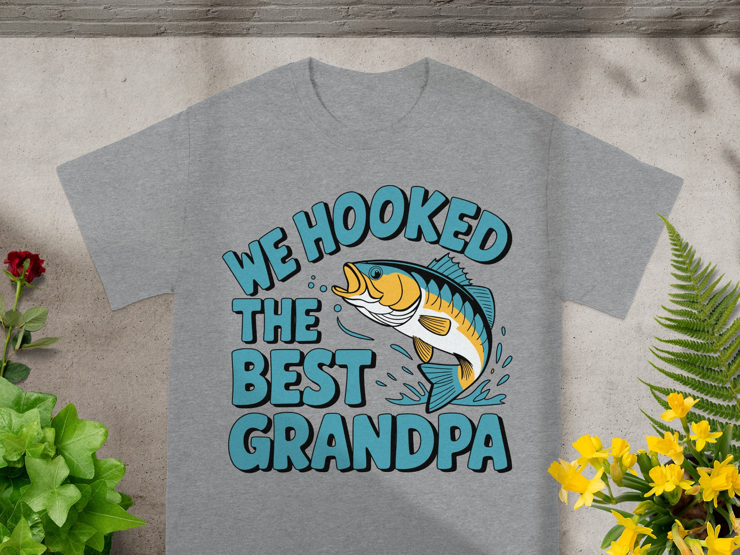 Gray t-shirt with "WE HOOKED THE BEST GRANDPA" and a jumping bass fish graphic.