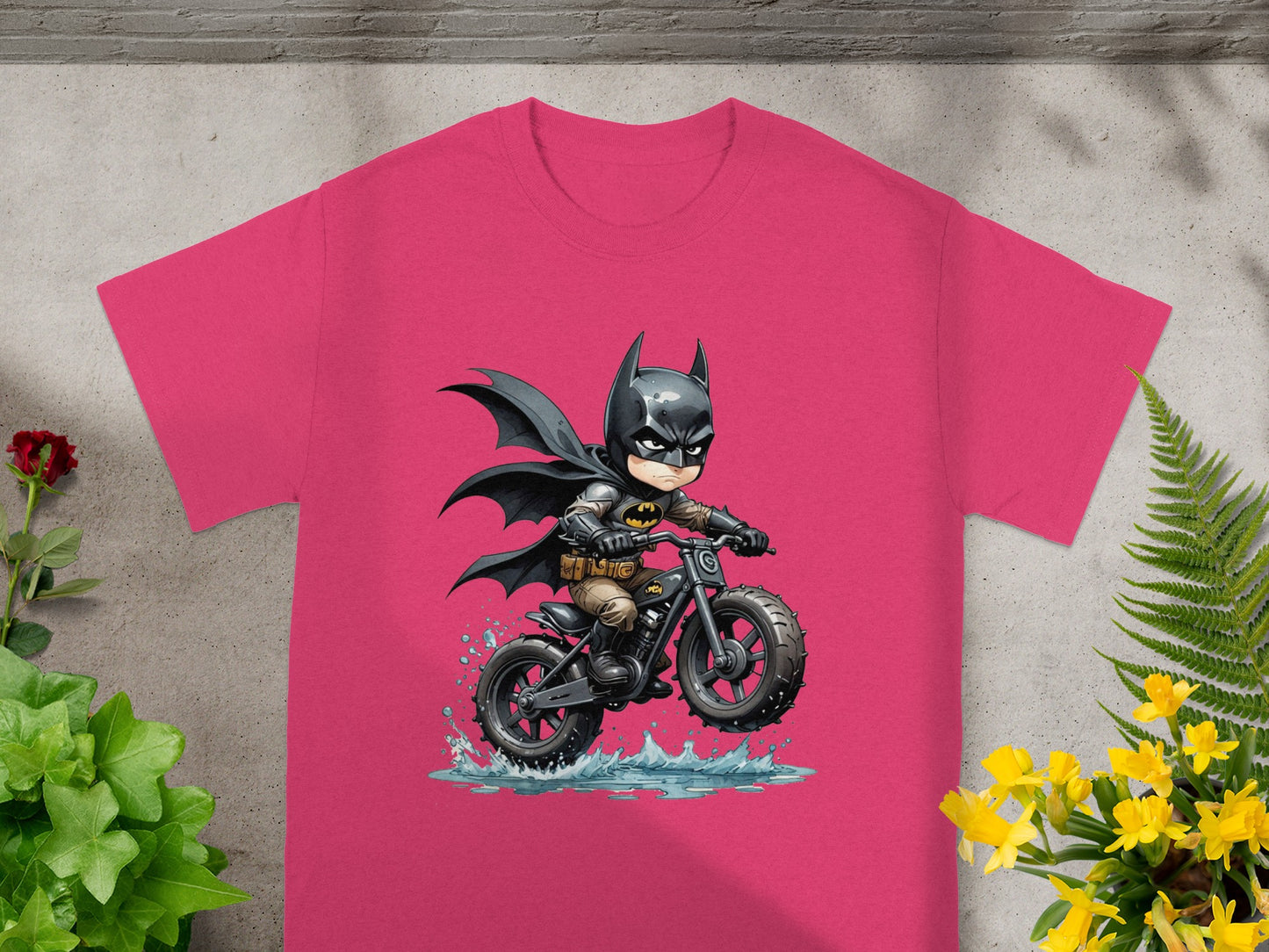 Batman character riding a motorcycle through water on a pink t-shirt.