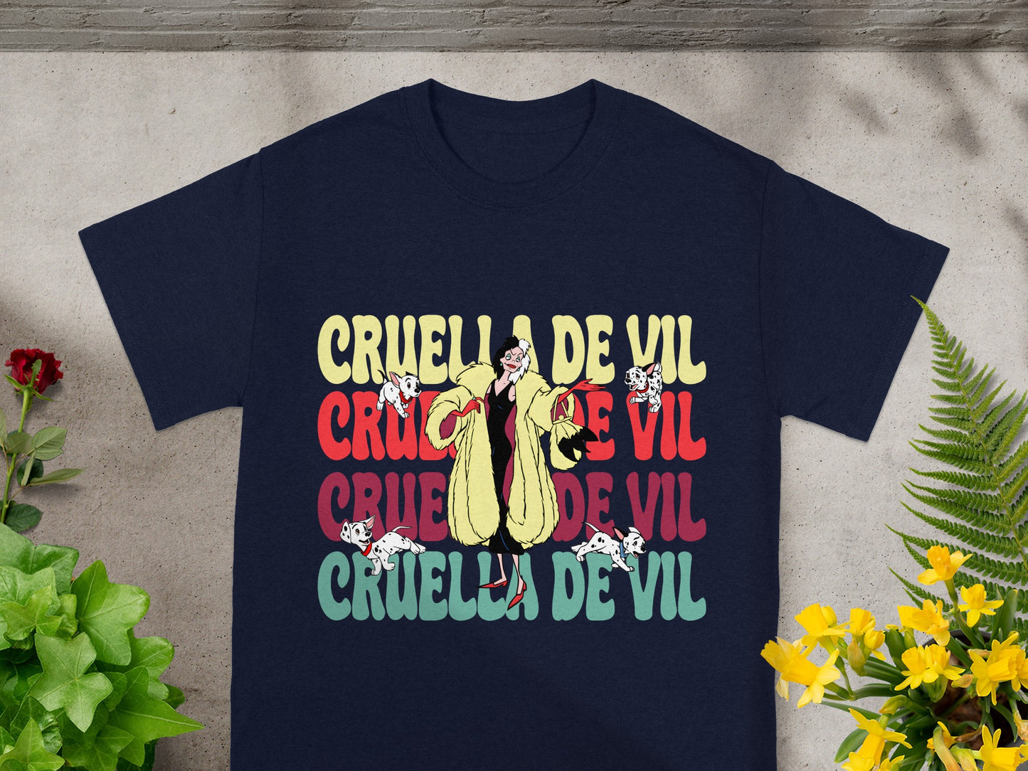 Navy t-shirt with "Cruella De Vil" repeated in colorful distressed font.