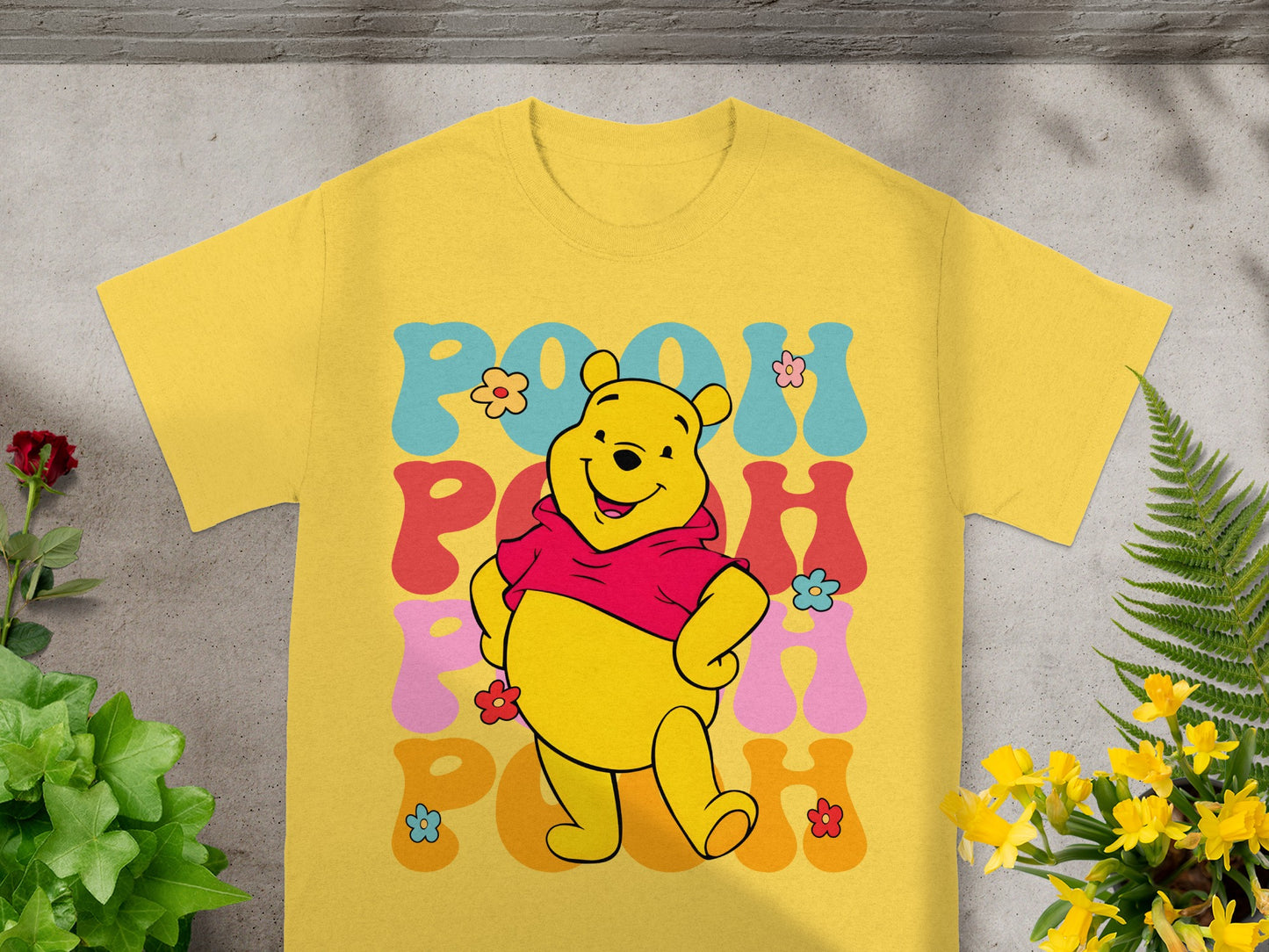 Yellow t-shirt featuring Winnie the Pooh in a retro style with colorful "POOH" text.