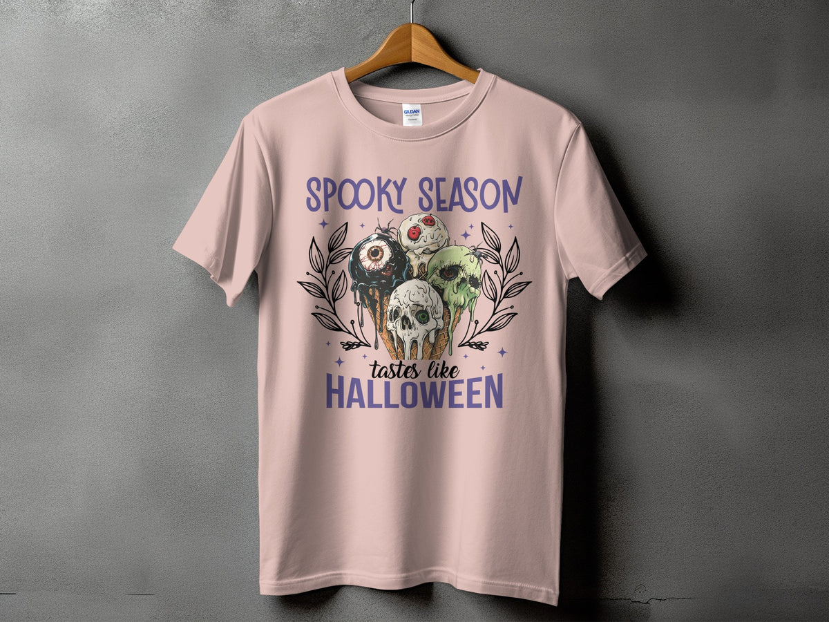 Pink t-shirt with "Spooky Season Tastes Like Halloween" text and Halloween-themed ice cream cones.