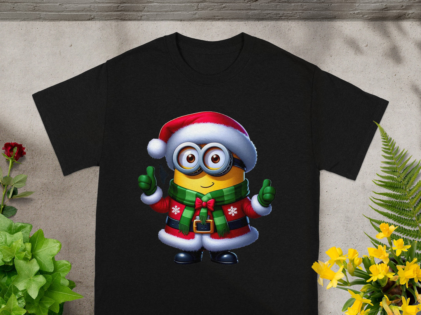 Minion in Santa outfit with green scarf giving thumbs up on black t-shirt.