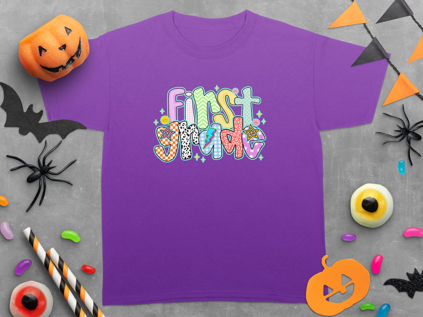 Purple t-shirt with "First Grade" text in colorful, patterned lettering.