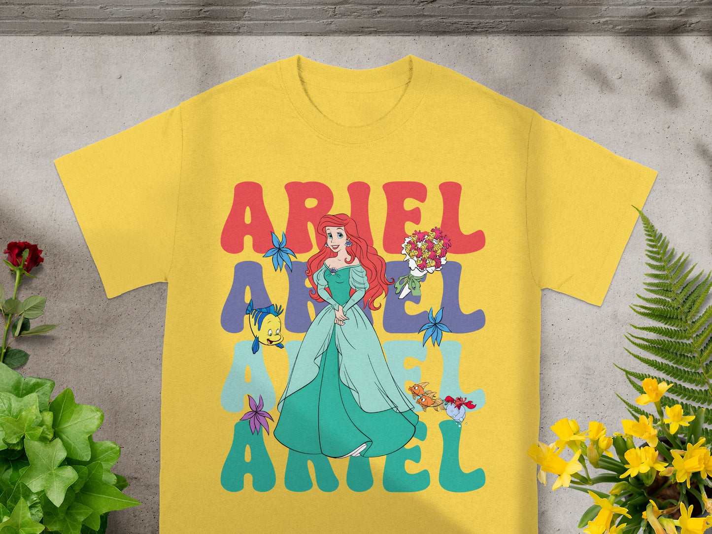 Yellow t-shirt with Ariel and colorful "Ariel" text.