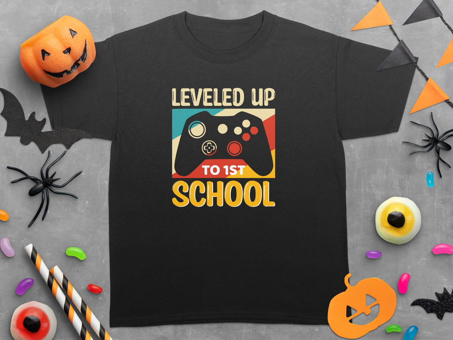 Black t-shirt with "Leveled Up To 1st School" and a vintage video game controller graphic.