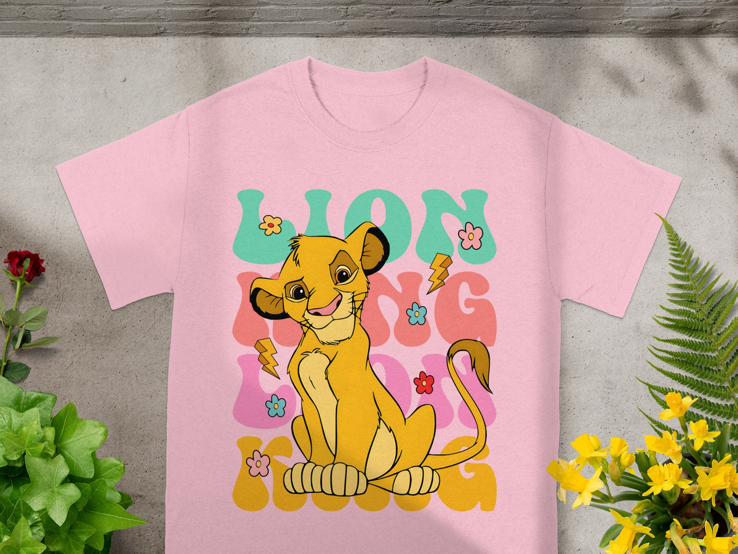 Pink t-shirt featuring Simba from The Lion King with "LION KING" text.
