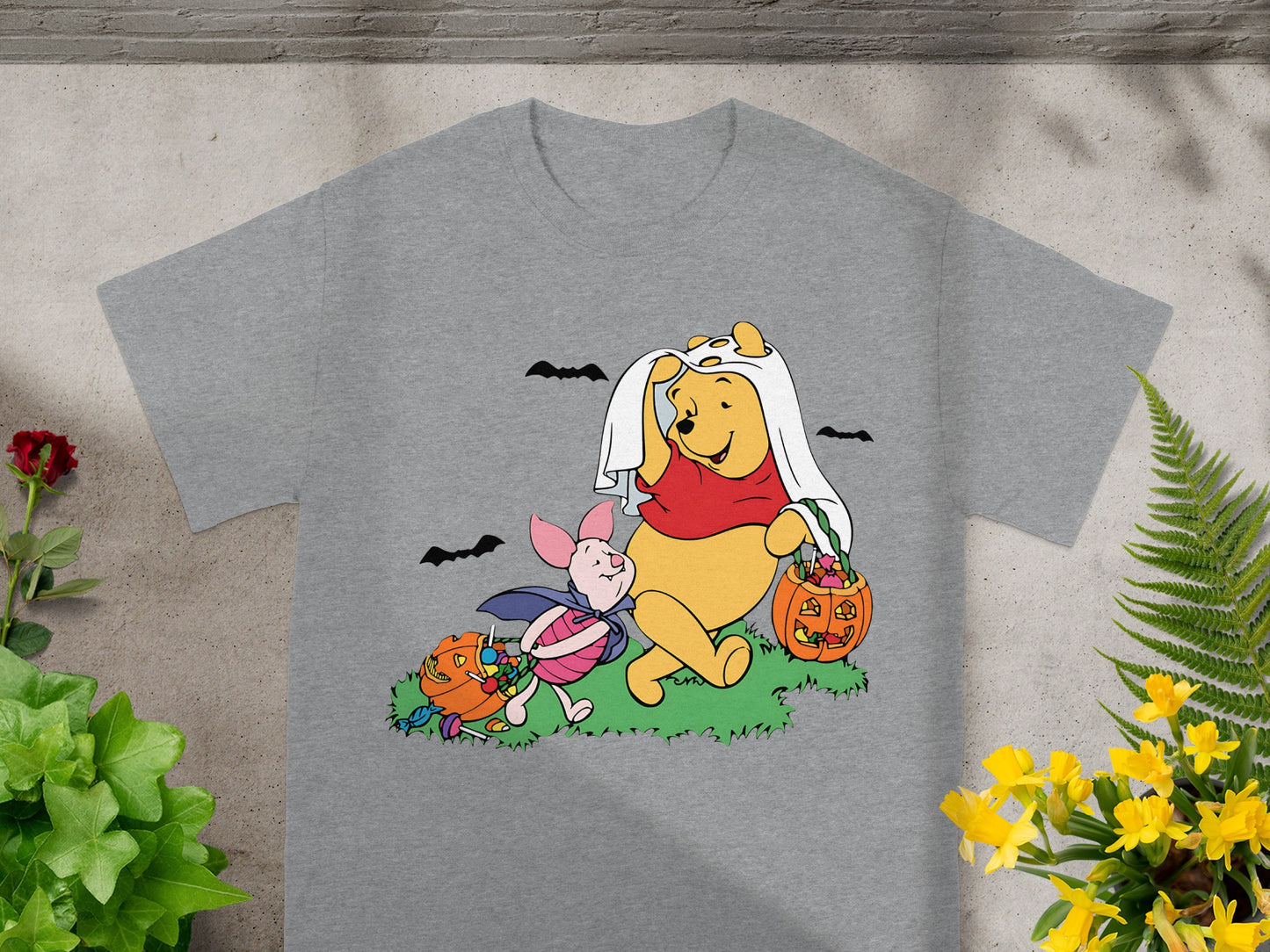 Winnie the Pooh and Piglet in Halloween costumes with candy and pumpkins.