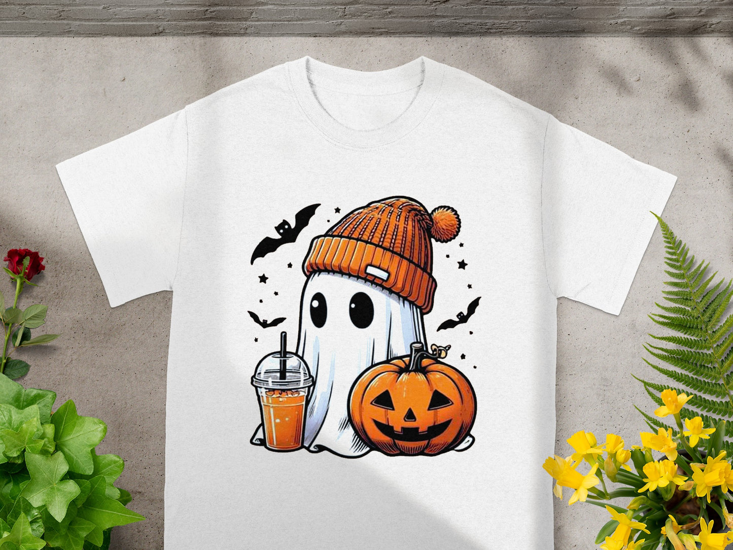 White t-shirt with cartoon ghost, pumpkin, drink, and bats for Halloween.