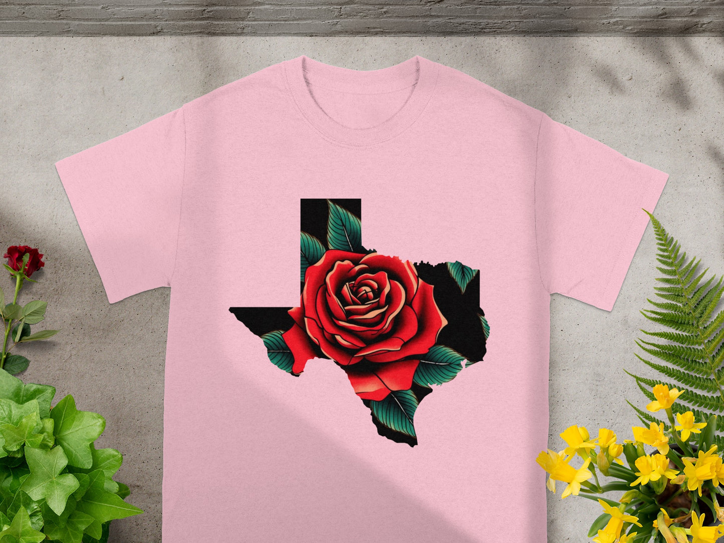 Pink t-shirt with Texas outline filled by a red rose and green leaves design.