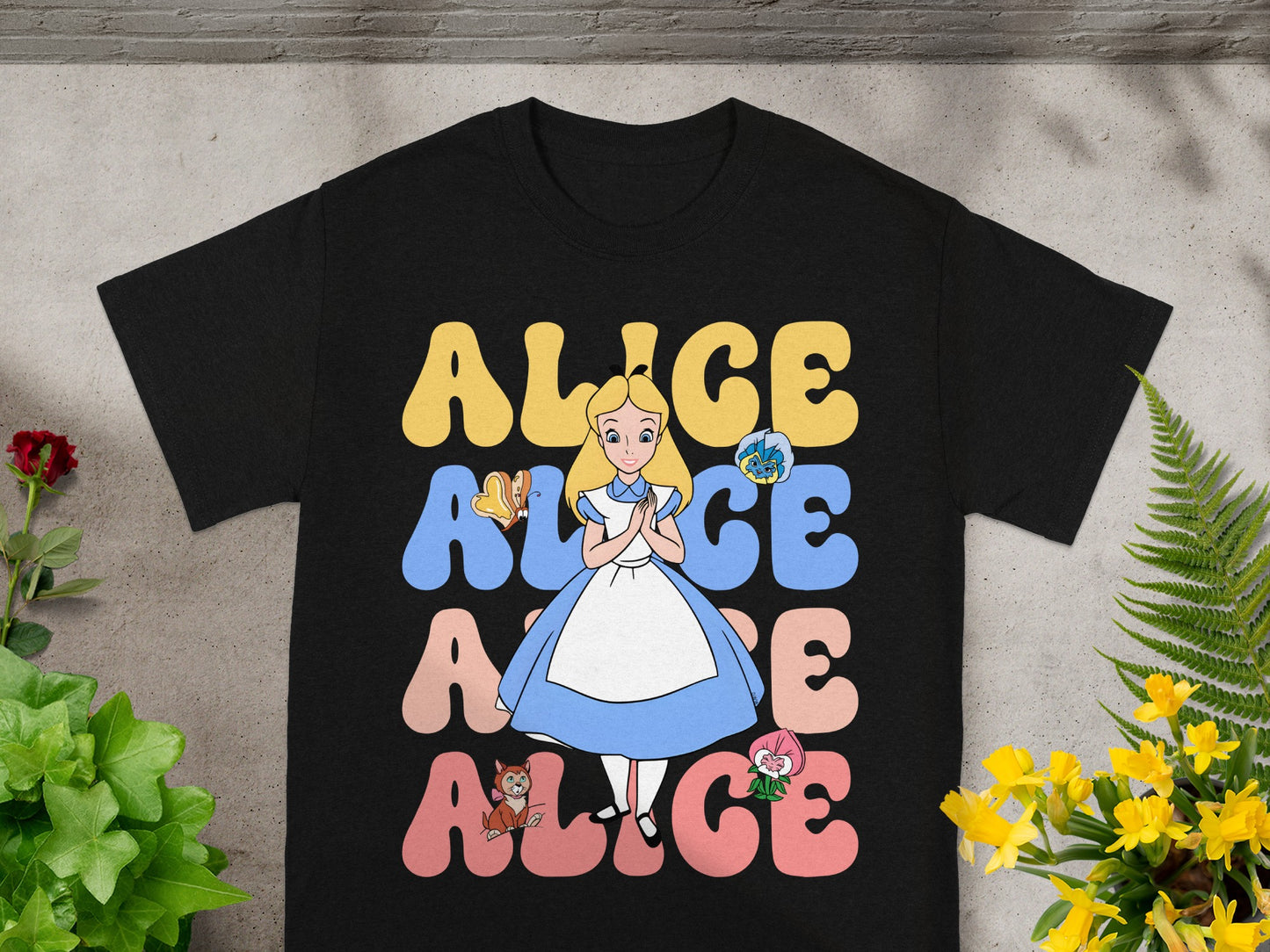 Black t-shirt with Alice in Wonderland characters and text.