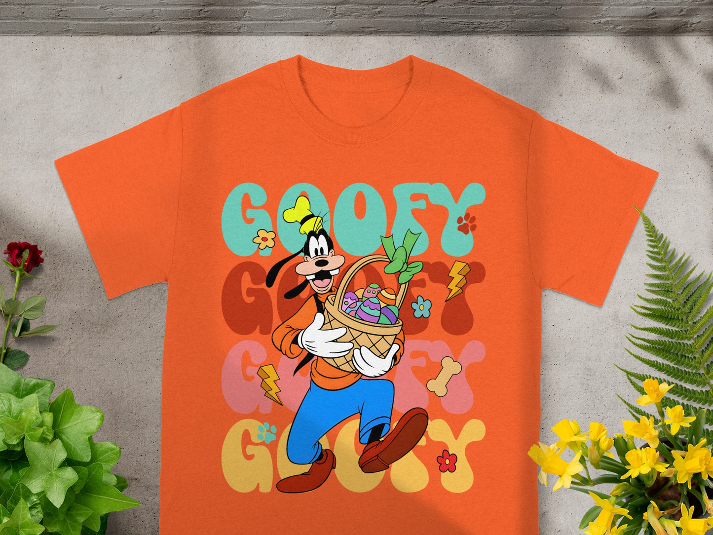 Orange t-shirt with Goofy holding an Easter basket and colorful graphic text.