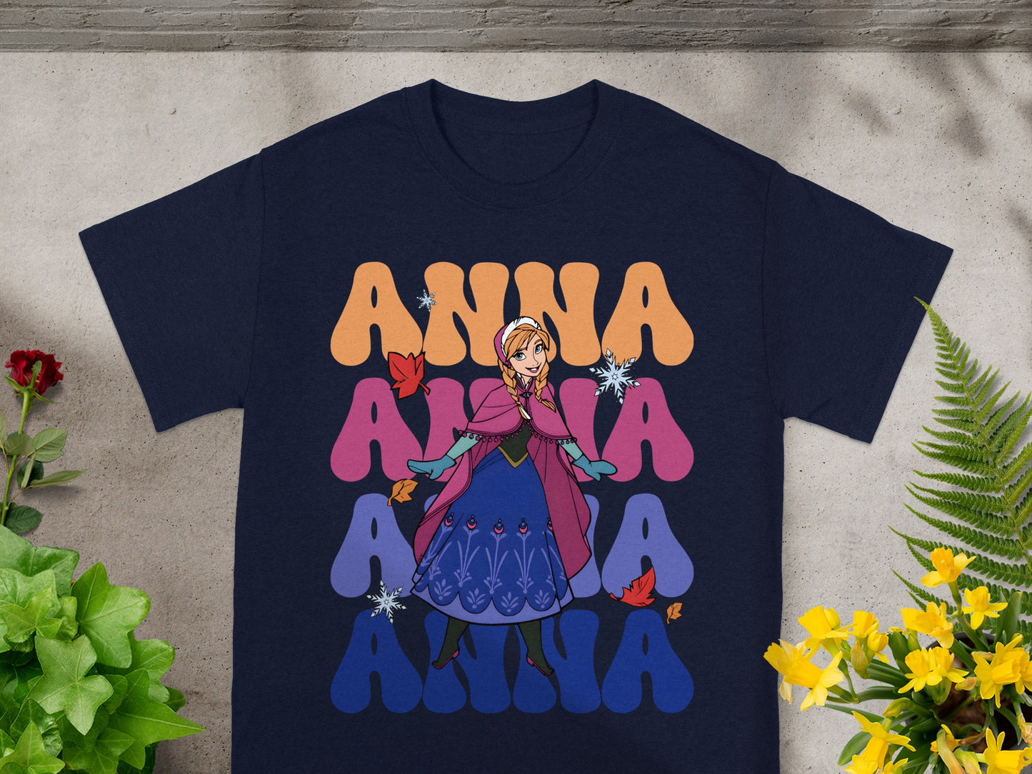 Navy t-shirt with "Anna" in colorful retro font and a character illustration.