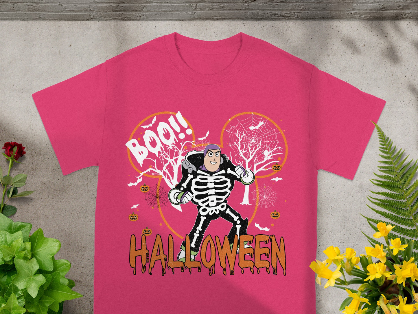 Buzz Lightyear in skeleton costume with "Boo!!" and "Halloween" text on a pink t-shirt.