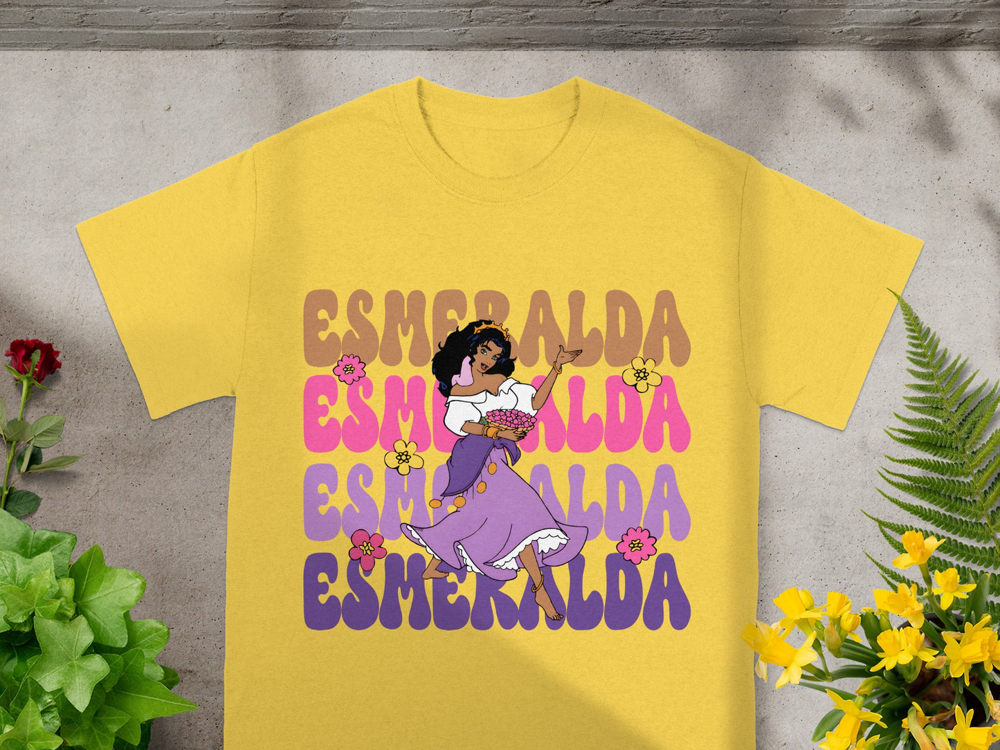 Yellow t-shirt with "ESMERALDA" in colorful, groovy text and a cartoon woman.