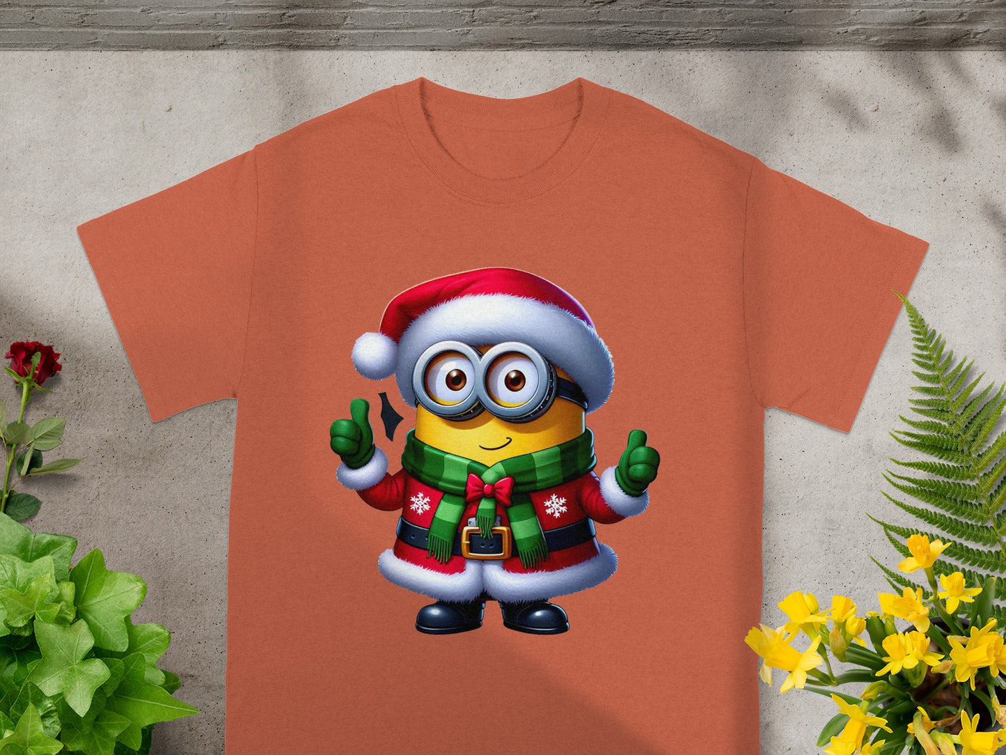Minion in Santa costume giving thumbs up on orange t-shirt.