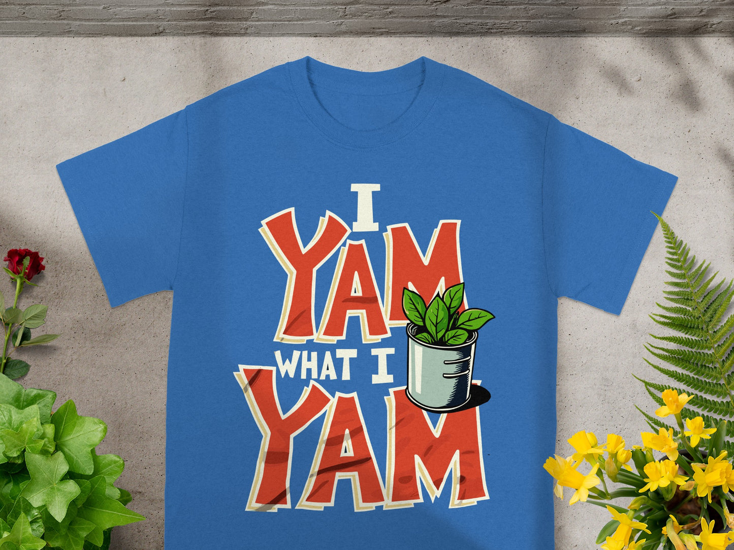 Blue t-shirt with "I Yam What I Yam" text and a small potted plant.