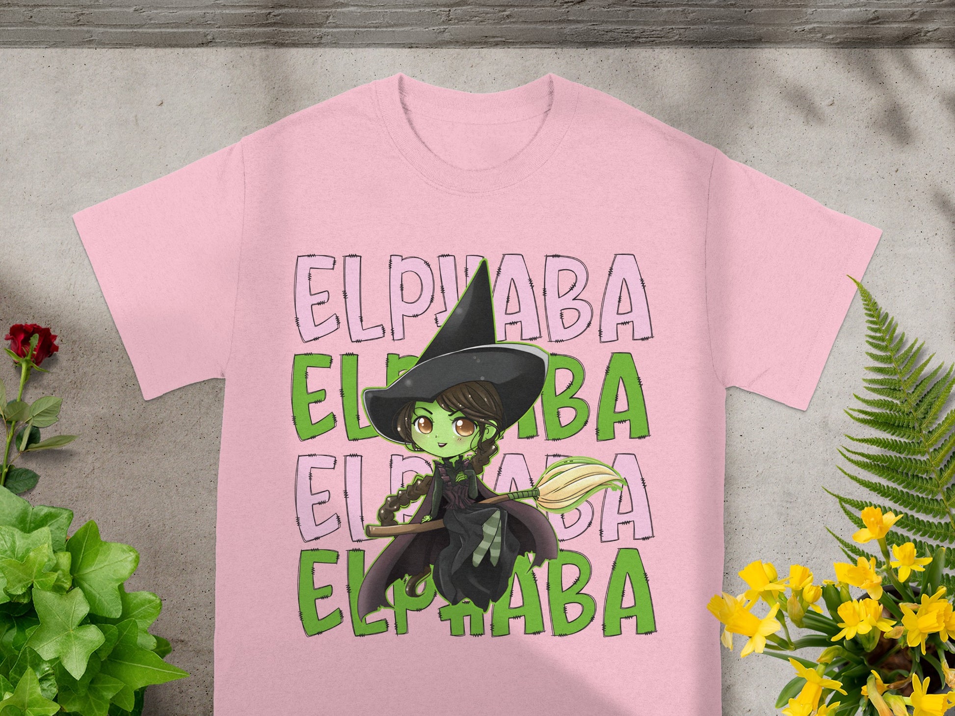 Pink t-shirt with "Elphaba" text and a witch illustration holding a broom.