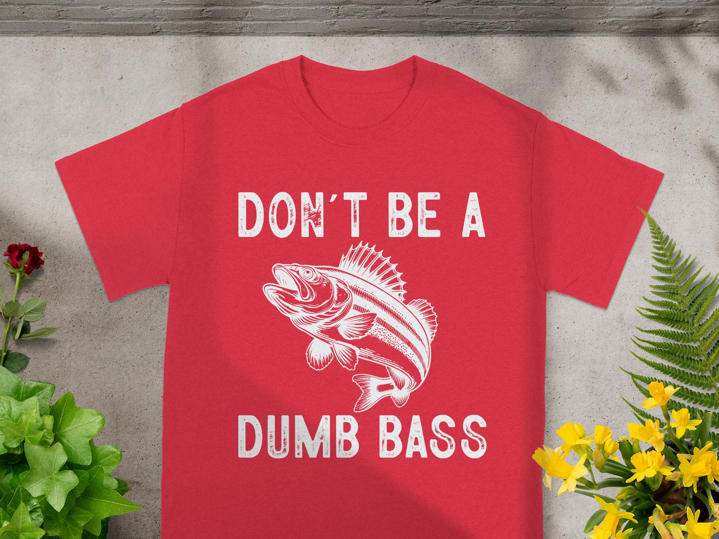 Red t-shirt with white text "DON'T BE A DUMB BASS" and a fish graphic.