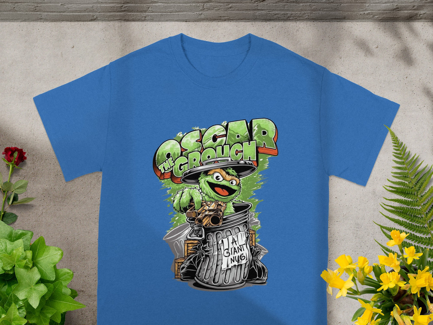 Oscar the Grouch character emerging from a trash can on a blue t-shirt.