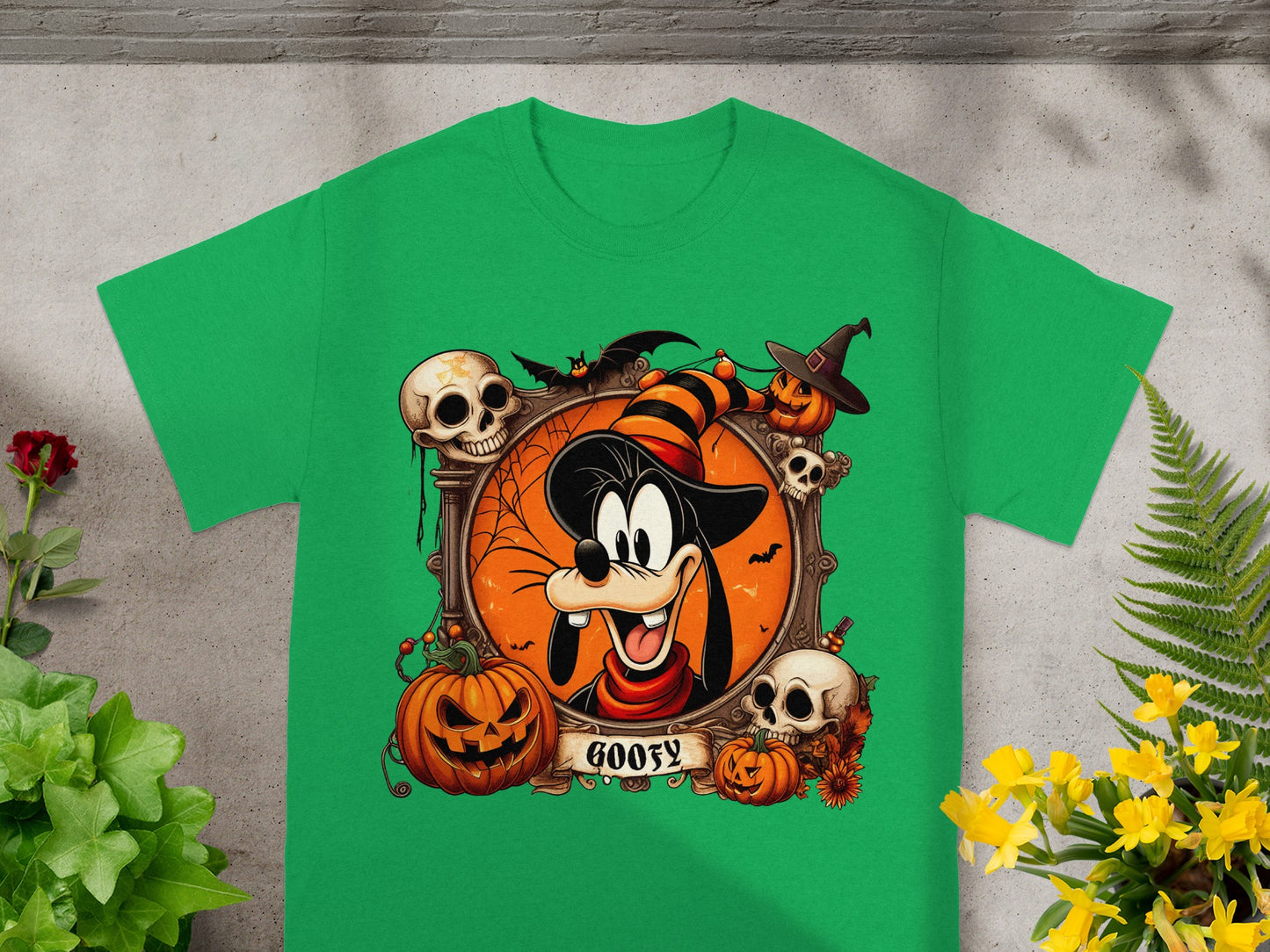 Green t-shirt with a Halloween design featuring Goofy in a witch hat and pumpkins.