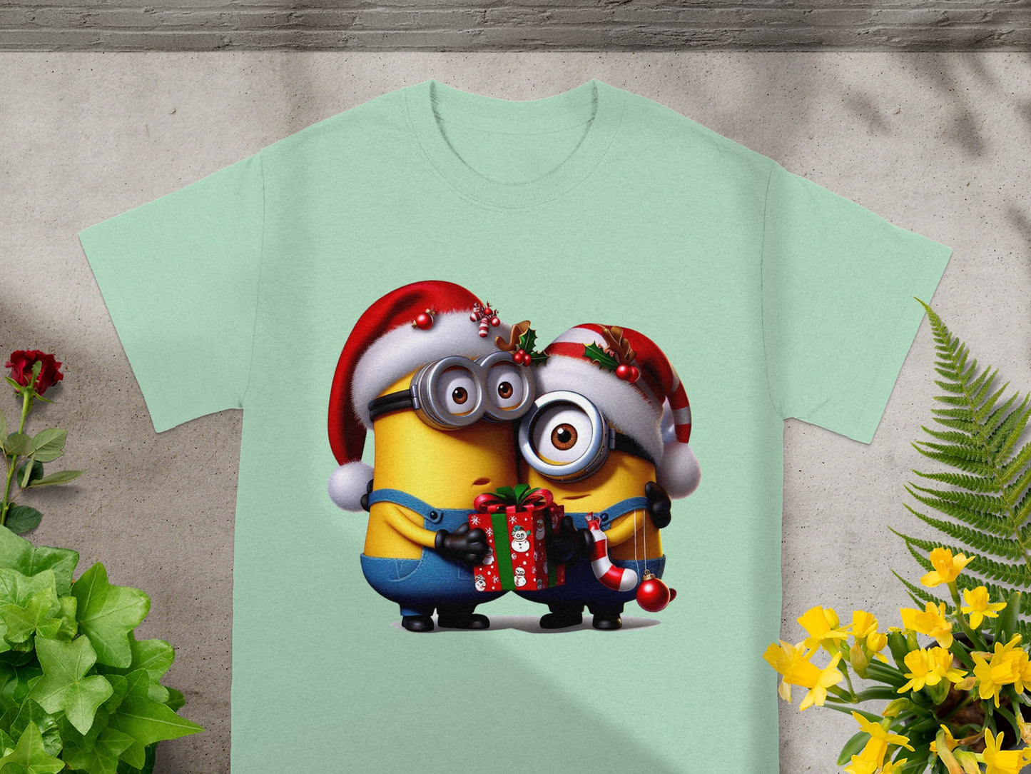 Two Minions wearing Santa hats share a gift and candy cane.