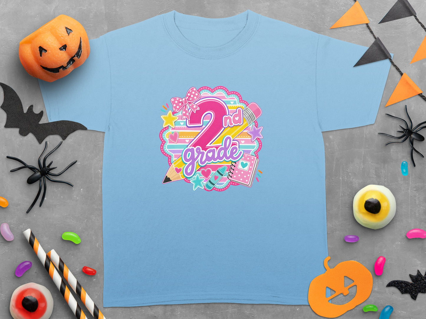 Light blue t-shirt with "2nd grade" graphic surrounded by school supplies and Halloween decorations.