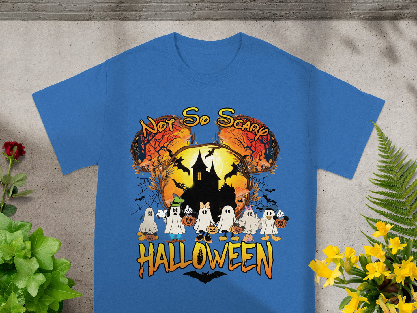 Blue t-shirt with cartoon ghosts holding pumpkins, "Not So Scary Halloween" text, and haunted castle graphic.