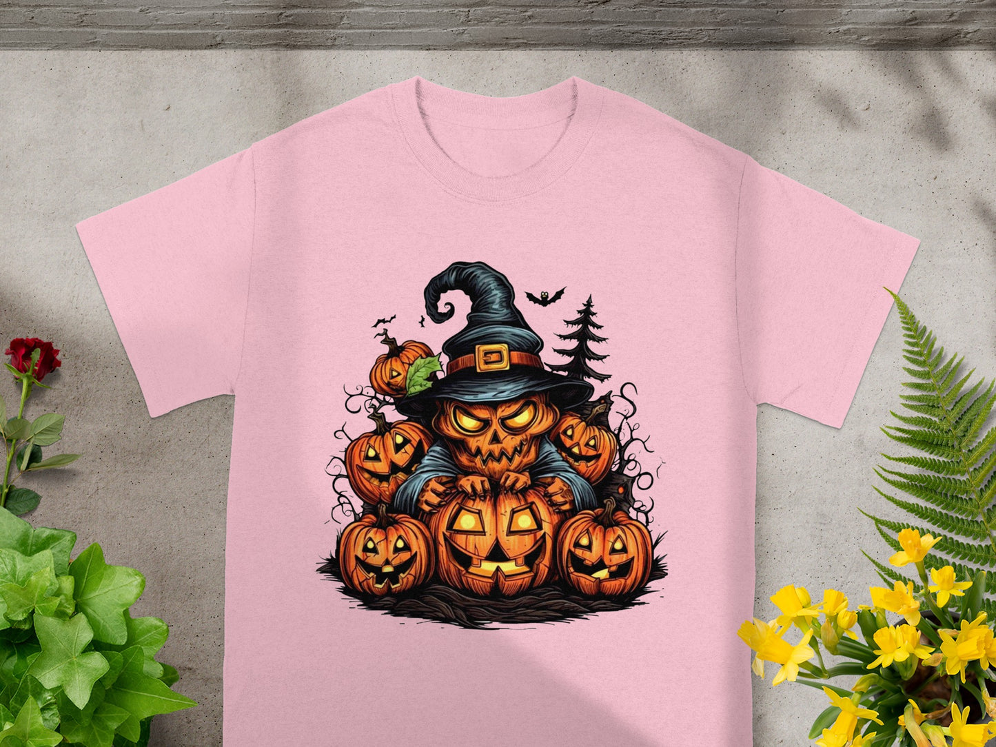 Halloween graphic on pink t-shirt with jack-o'-lanterns and a witch hat.