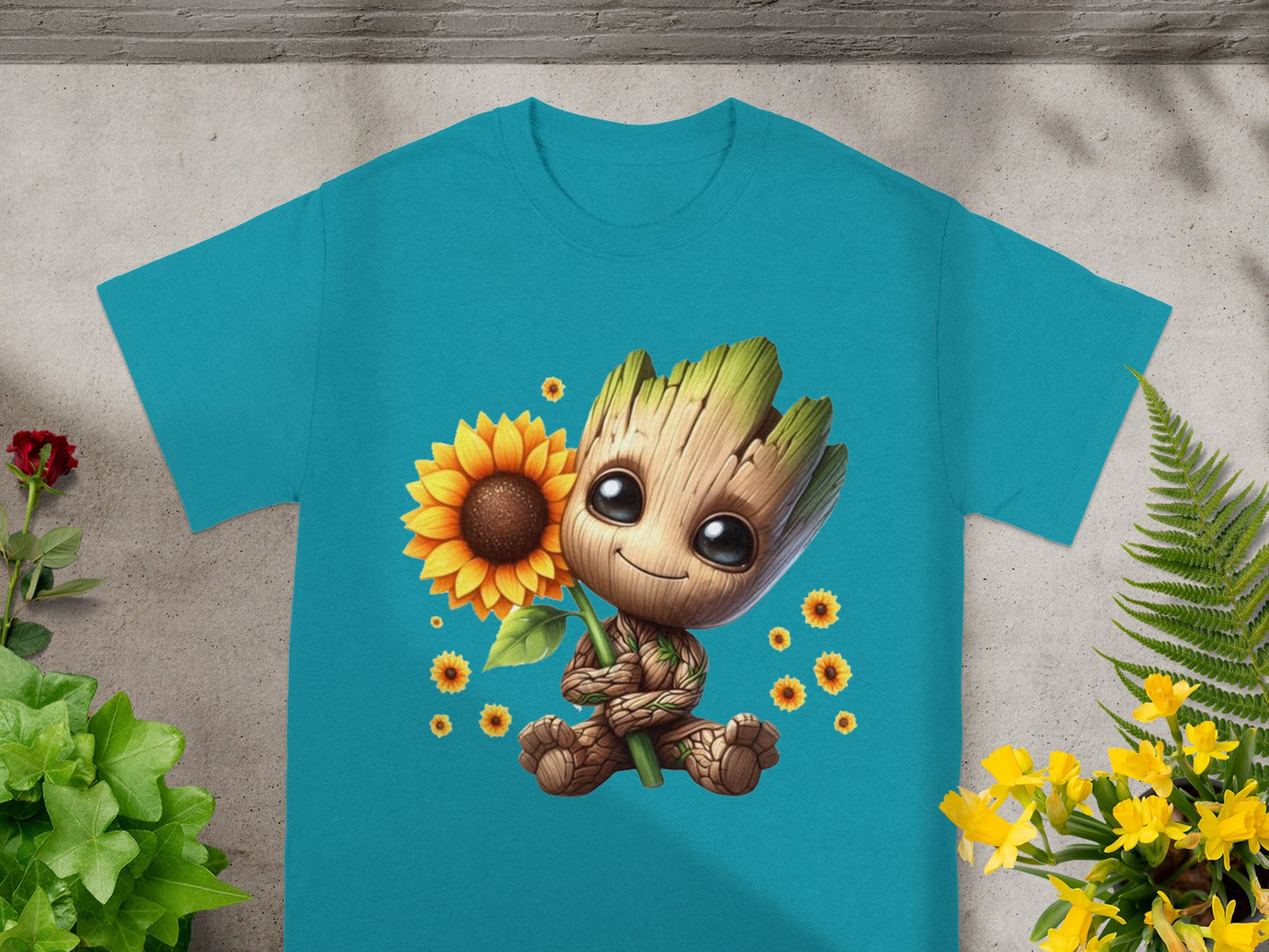 Groot holding a sunflower, surrounded by smaller sunflowers, on a teal t-shirt.