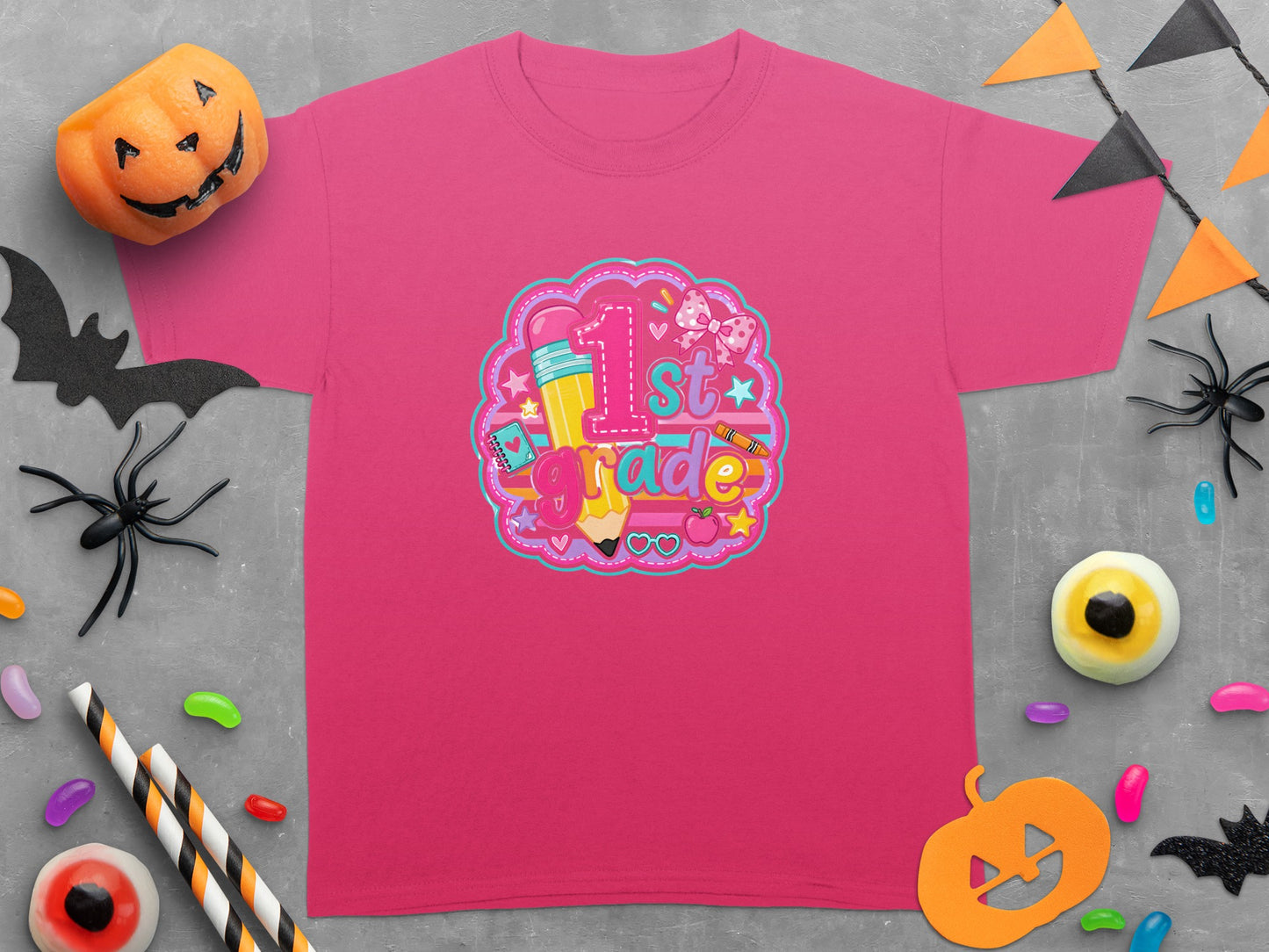 Pink t-shirt with "1st grade" in colorful graphic featuring a pencil and bow.