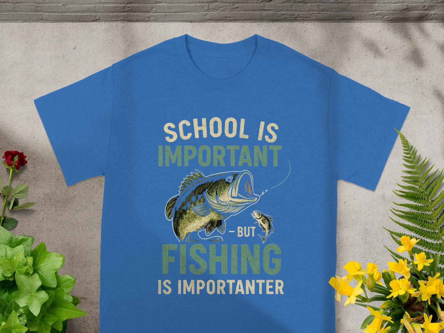Blue t-shirt with graphic of a fish on a line and text "SCHOOL IS IMPORTANT - BUT FISHING IS IMPORTANTER".
