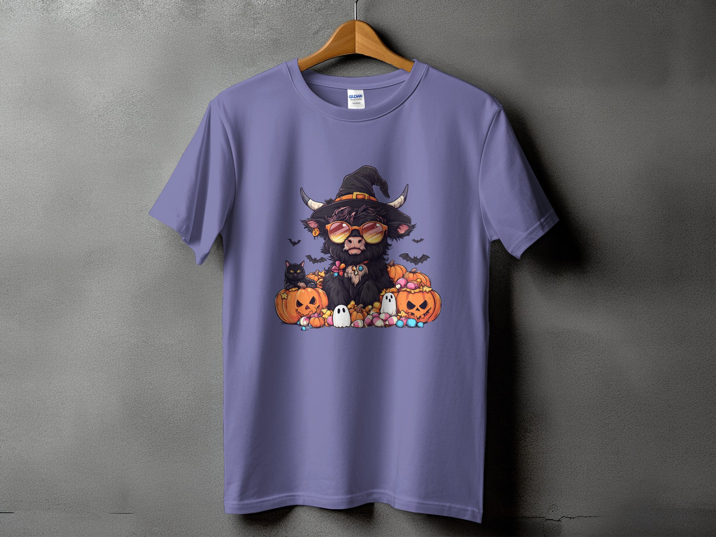 T-shirt with Highland cow in witch hat, sunglasses, pumpkins, ghosts, and candy graphic.