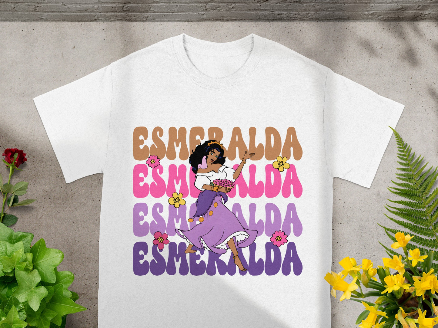 White t-shirt featuring a colorful cartoon graphic of Esmeralda dancing.