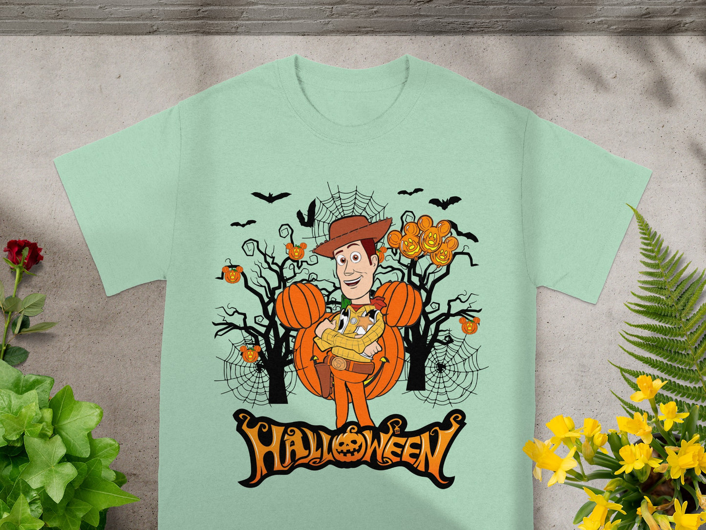 Woody character with pumpkins and bats on a light green Halloween t-shirt.