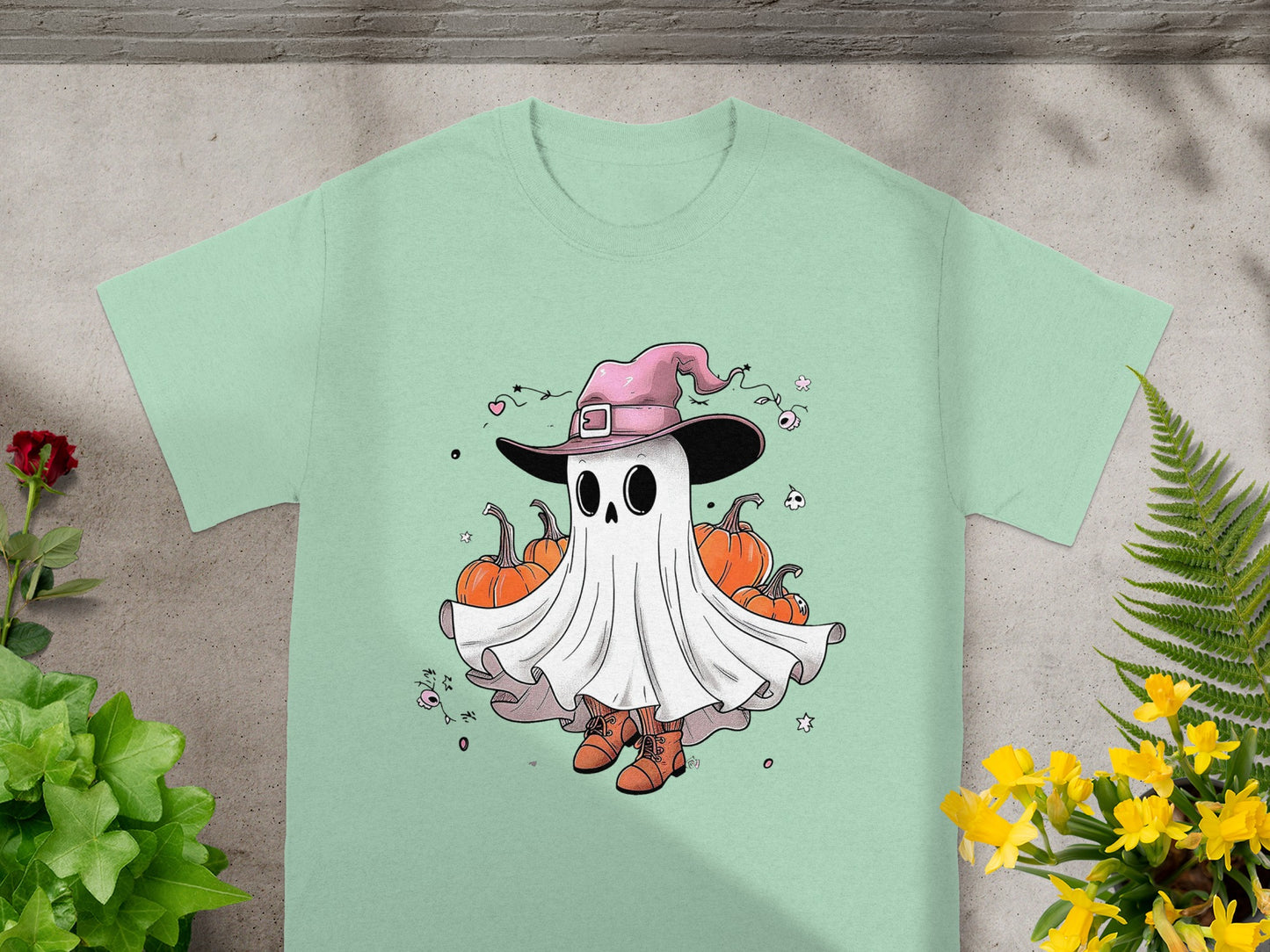 A cartoon ghost wearing a pink witch hat and orange boots stands among pumpkins.