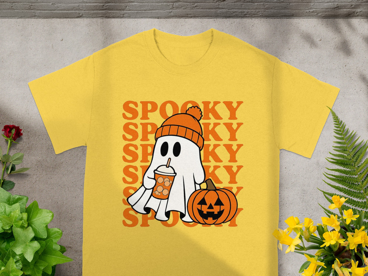 Yellow t-shirt with a graphic of a ghost holding a drink and a pumpkin, text "SPOOKY" vertically.