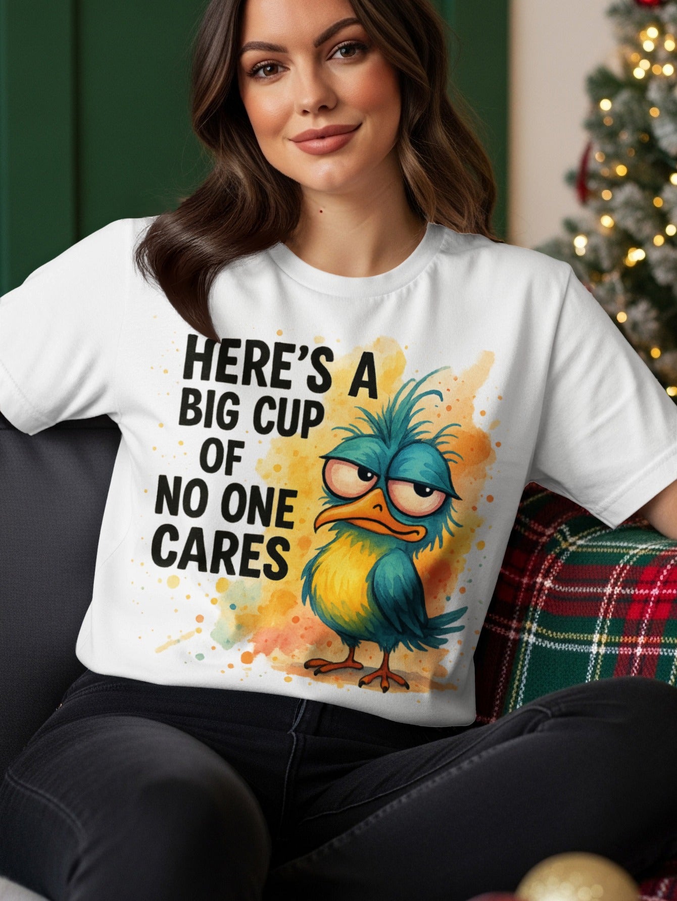 White t-shirt with a blue bird graphic and text "HERE'S A BIG CUP OF NO ONE CARES".