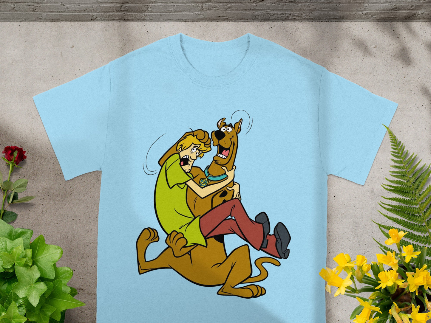 Shaggy holds Scooby-Doo in a playful embrace on a light blue t-shirt.
