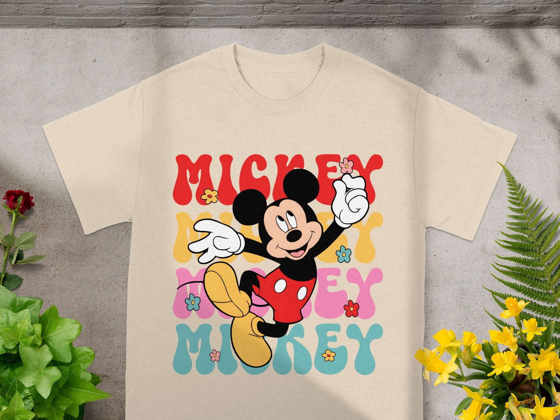 Mickey Mouse graphic tee with colorful "Mickey" text and floral accents.