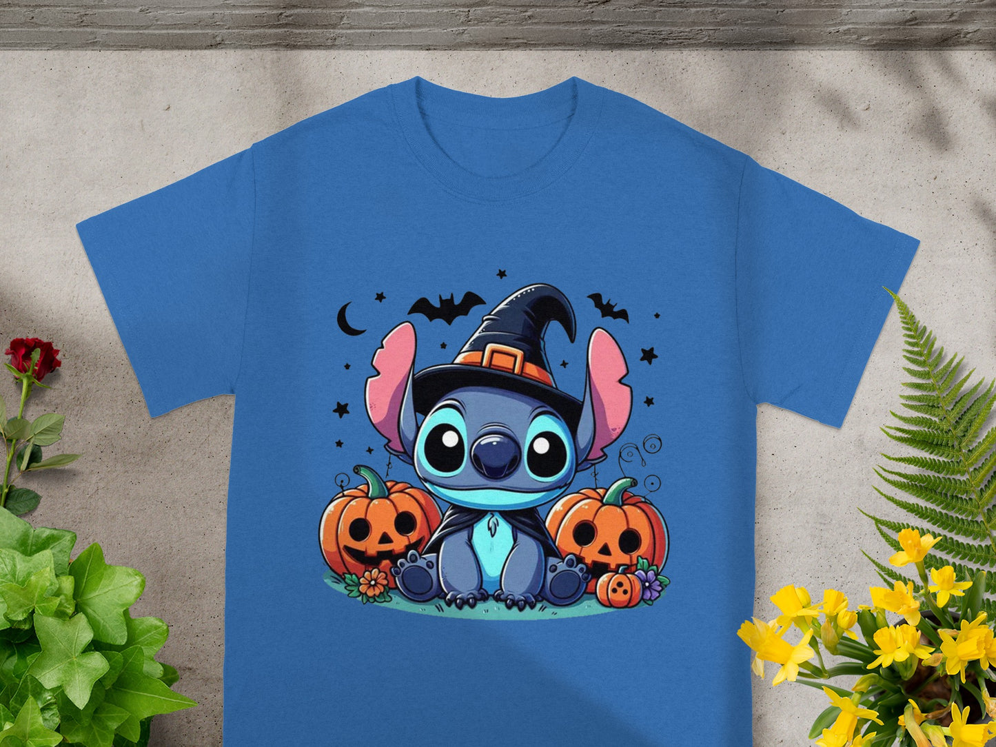 Stitch wearing a witch hat sits between pumpkins with bats and stars.