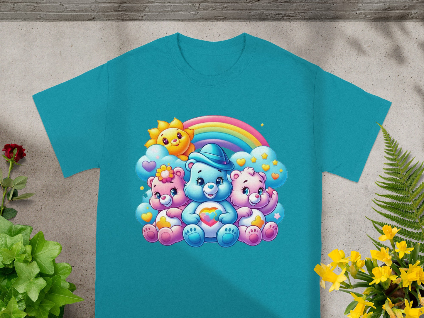 Three Care Bears with a sun and rainbow illustration on a teal t-shirt.