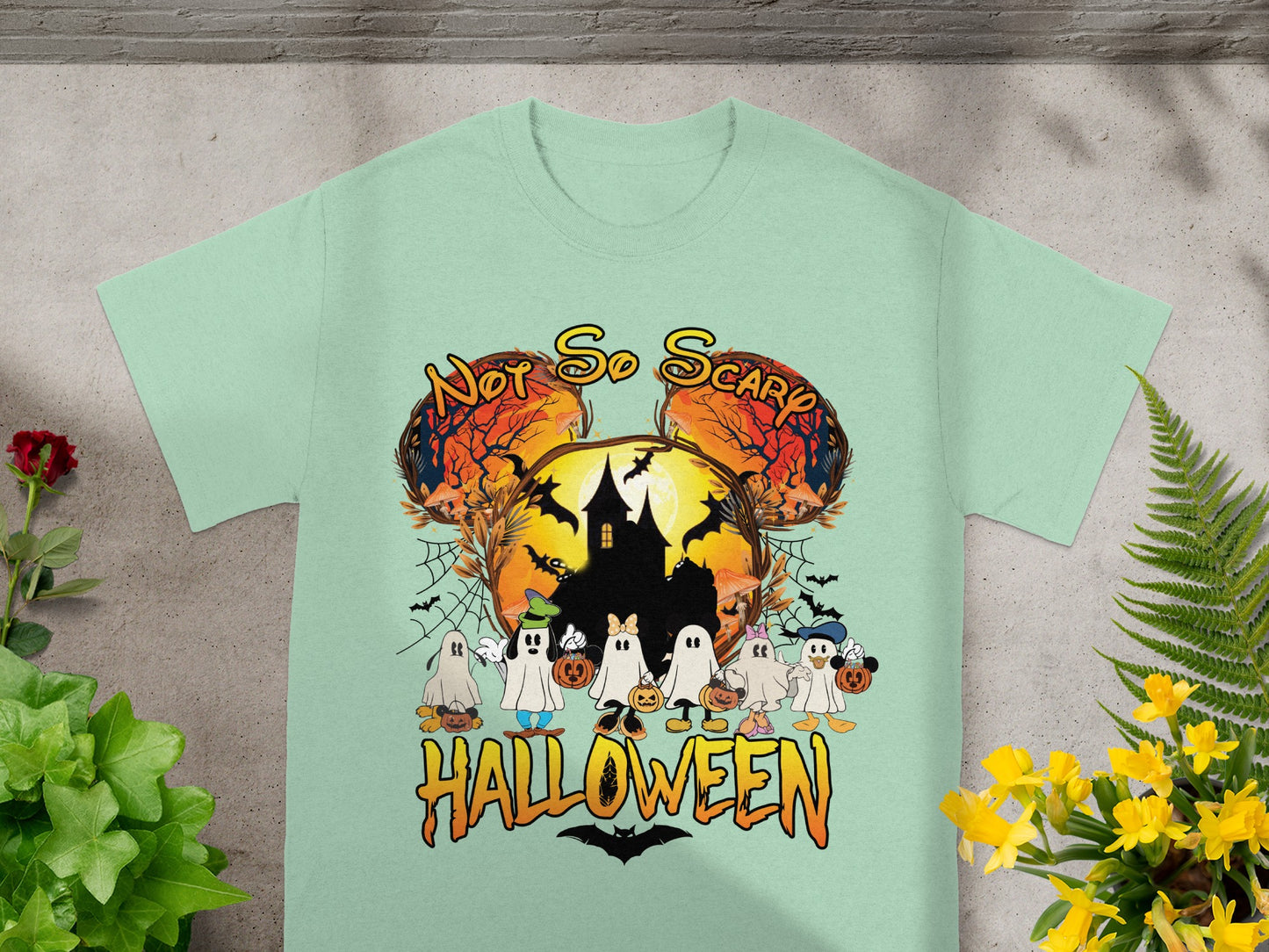 Ghost characters and text that says "Not So Scary Halloween" on a light green t-shirt.
