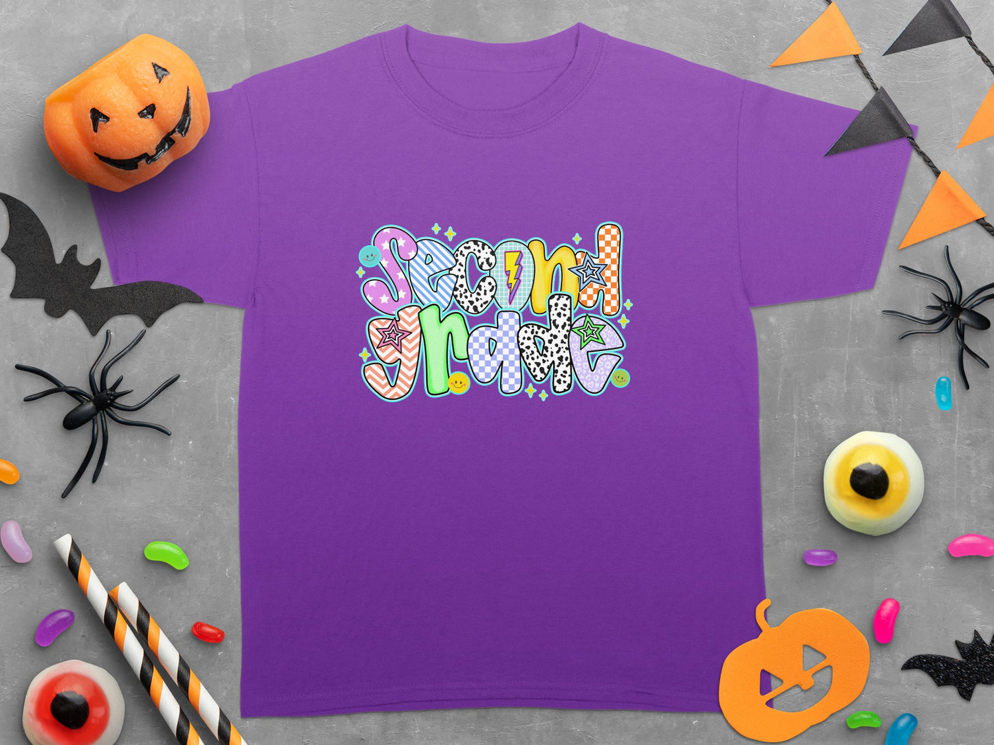 Purple t-shirt with "Second Grade" text in colorful, varied patterns and Halloween decorations.